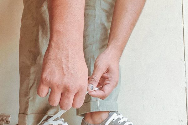 A close-up shot of a man's hands gripping the floor during a plank.